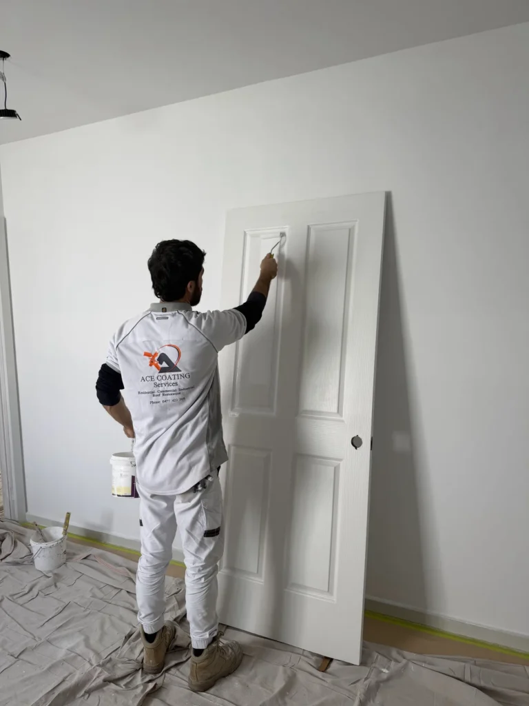 Ace Coating Services painter painting an interior door during a residential painting job in Melbourne