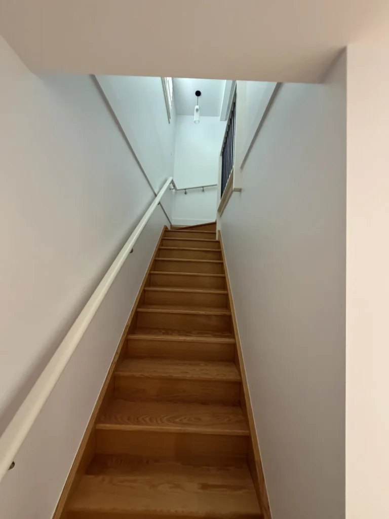 Timber staircase with freshly painted white walls and ceiling – residential painting Melbourne by Ace Coating Services