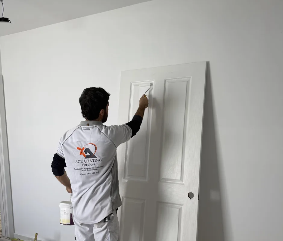 Ace Coating Services painter painting an interior door white during a residential painting job in Melbourne