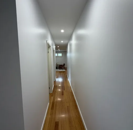 Freshly painted white hallway with timber floors – interior residential painting in Melbourne by Ace Coating Services